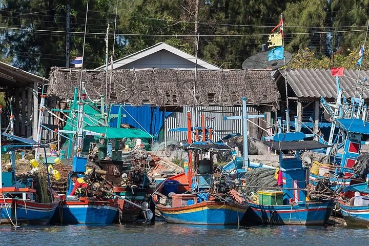 Barche da pesca colorate ormeggiate in fila lungo uno stretto canale